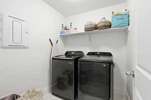 Laundry area featuring separate washer and dryer and light marble finish floors