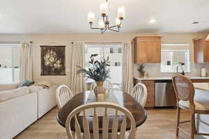 Dining room featuring light wood finished floors, recessed lighting, and a chandelier