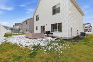 Snow covered rear of property with a patio, a trampoline, and a fenced backyard