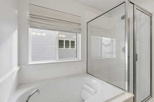 Full bath with a shower stall and a garden tub