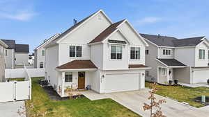 View of front of property with a gate, a shingled roof, board and batten siding, a garage, and driveway