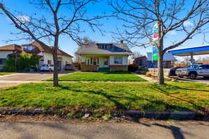 Bungalow featuring brick siding, a front lawn, and a chimney