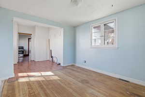 Spare room featuring light wood-style floors and baseboards