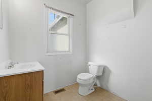 Half bathroom featuring vanity and toilet