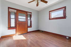 Empty room with light wood-style floors and ceiling fan
