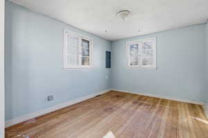 Empty room featuring light wood-style floors and electric panel