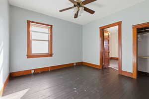 Unfurnished bedroom featuring dark wood finished floors and ceiling fan
