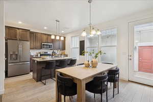 Dining area with light wood finished floors, recessed lighting, and a chandelier