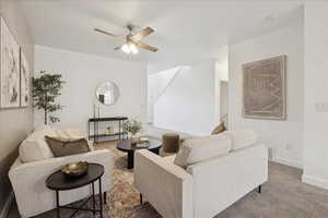 Carpeted living room with baseboards and ceiling fan