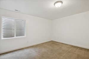 Empty room featuring light carpet and baseboards