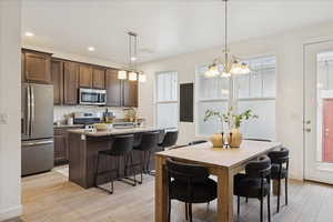 Dining area featuring recessed lighting, light wood-style floors, and a chandelier