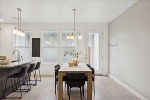 Dining area featuring light wood-type flooring and a chandelier