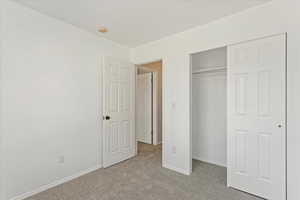 Unfurnished bedroom featuring light colored carpet and a closet