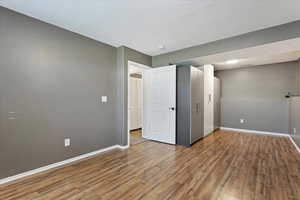 Unfurnished bedroom with light wood finished floors and baseboards