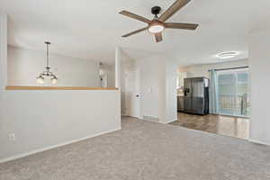 Unfurnished room featuring carpet flooring, a chandelier, and a ceiling fan