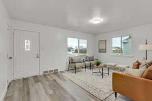 Foyer with light wood finished floors and baseboards