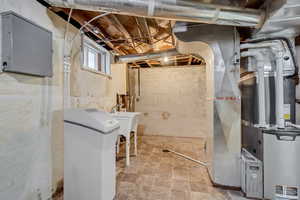 Below grade area featuring a water softener and heating unit