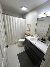 Bathroom featuring vanity, a shower with shower curtain, a textured ceiling, and light tile patterned floors