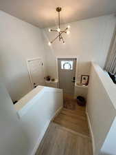 Stairway featuring wood finished floors and a chandelier