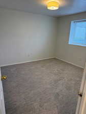 Carpeted spare room with baseboards