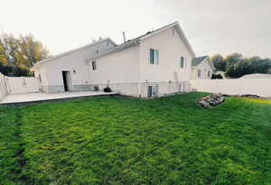 Back of house featuring a fenced backyard, a patio, and a gate