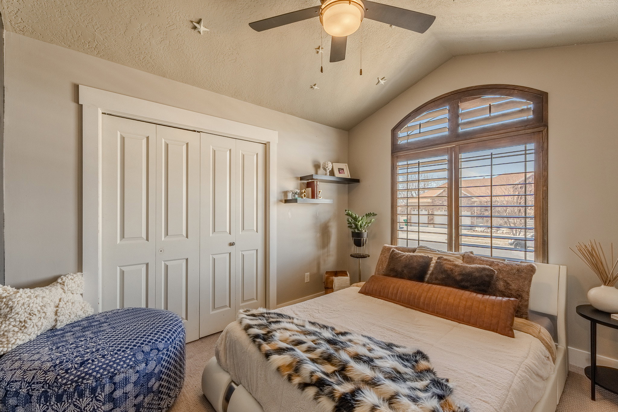 Bedroom featuring lofted ceiling, a closet, a ceiling fan, carpet flooring, and a textured ceiling