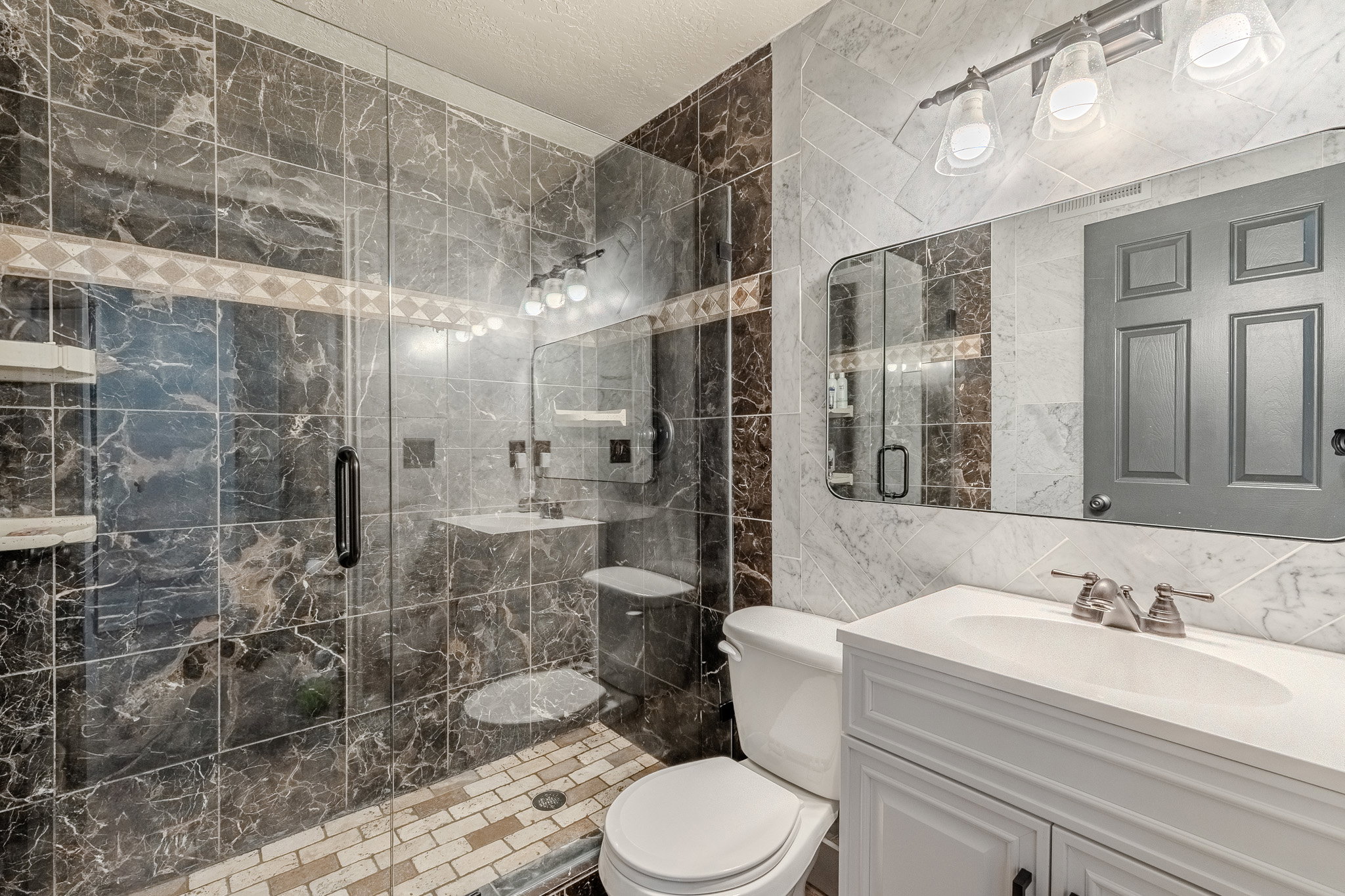 Bathroom featuring tile walls, vanity, a stall shower, tasteful backsplash, and a textured ceiling