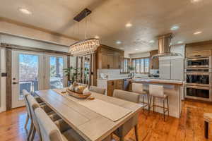 Dining space with a chandelier, light wood-style flooring, recessed lighting, and a textured ceiling