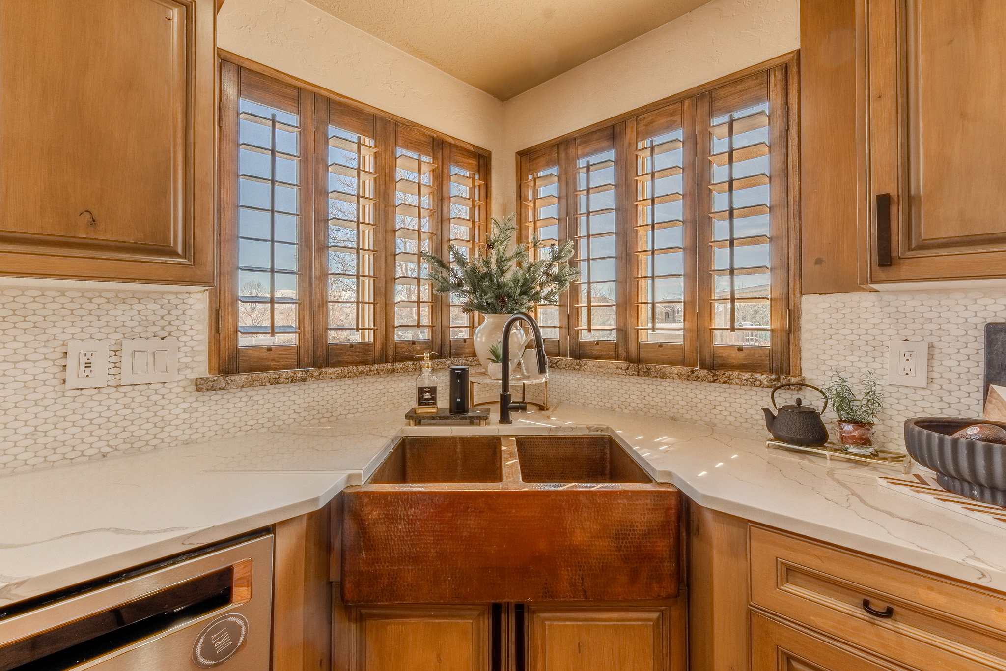 Kitchen featuring decorative backsplash, light stone countertops, and brown cabinetry
