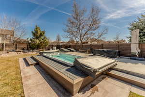 View of swimming pool with a deck, a patio area, and a fenced backyard