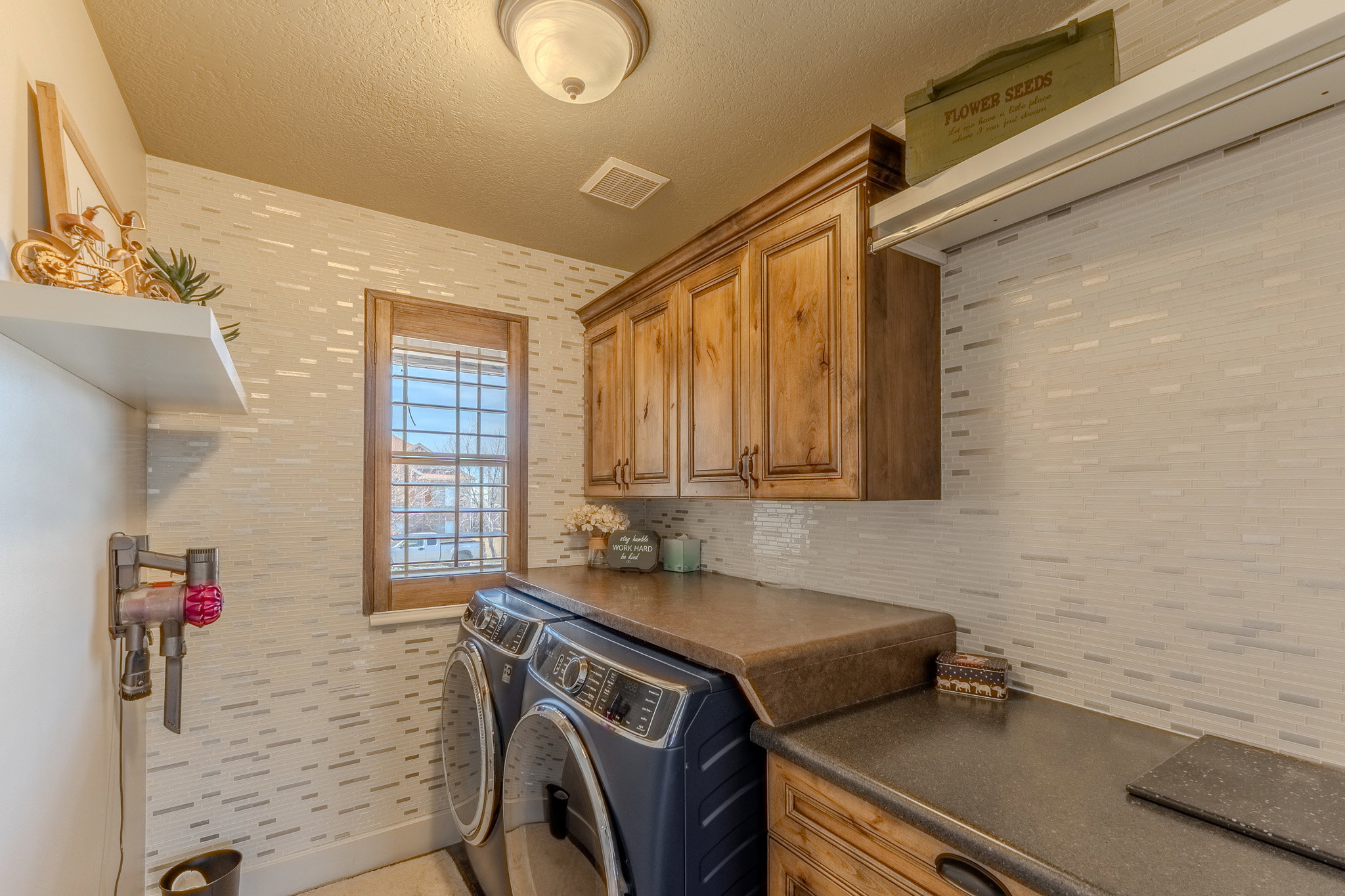 Washroom with a textured ceiling, washing machine and dryer, and cabinet space