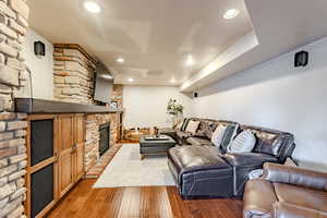 Living room with a fireplace, hardwood / wood-style flooring, and recessed lighting
