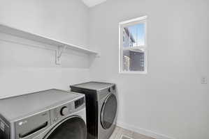 Washroom with separate washer and dryer and tile patterned flooring