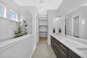 Owners full bath featuring double vanity, a spacious closet, and large walk in shower