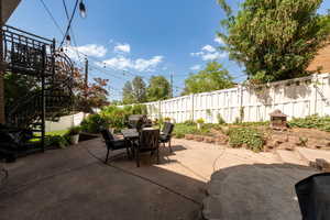 Fenced backyard featuring outdoor dining space, a patio area, and stairs