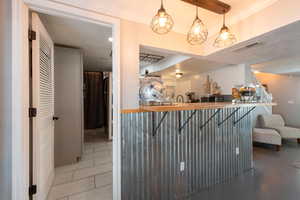 Bar featuring butcher block counters and pendant lighting