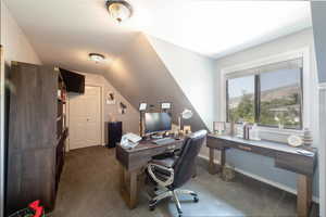 Office area featuring dark carpet and baseboards