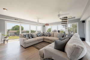 Living area featuring plenty of natural light, light wood-type flooring, a ceiling fan, and recessed lighting
