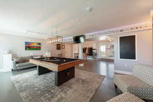 Rec room featuring billiards, a textured ceiling, finished concrete floors, and rail lighting