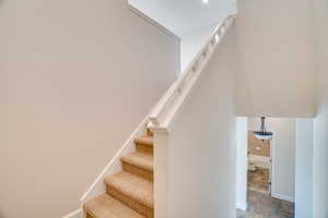 Stairway featuring stone finish flooring and baseboards