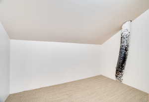 Bonus room featuring vaulted ceiling and carpet flooring