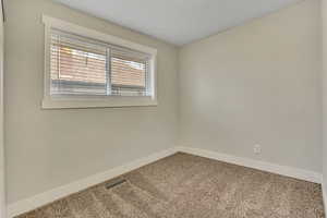 Carpeted spare room with baseboards