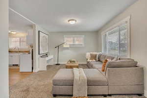 Living area featuring light carpet and baseboards