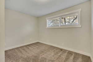 Spare room featuring carpet floors and baseboards