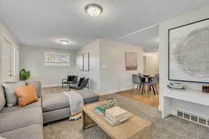 Living area with light carpet and baseboards