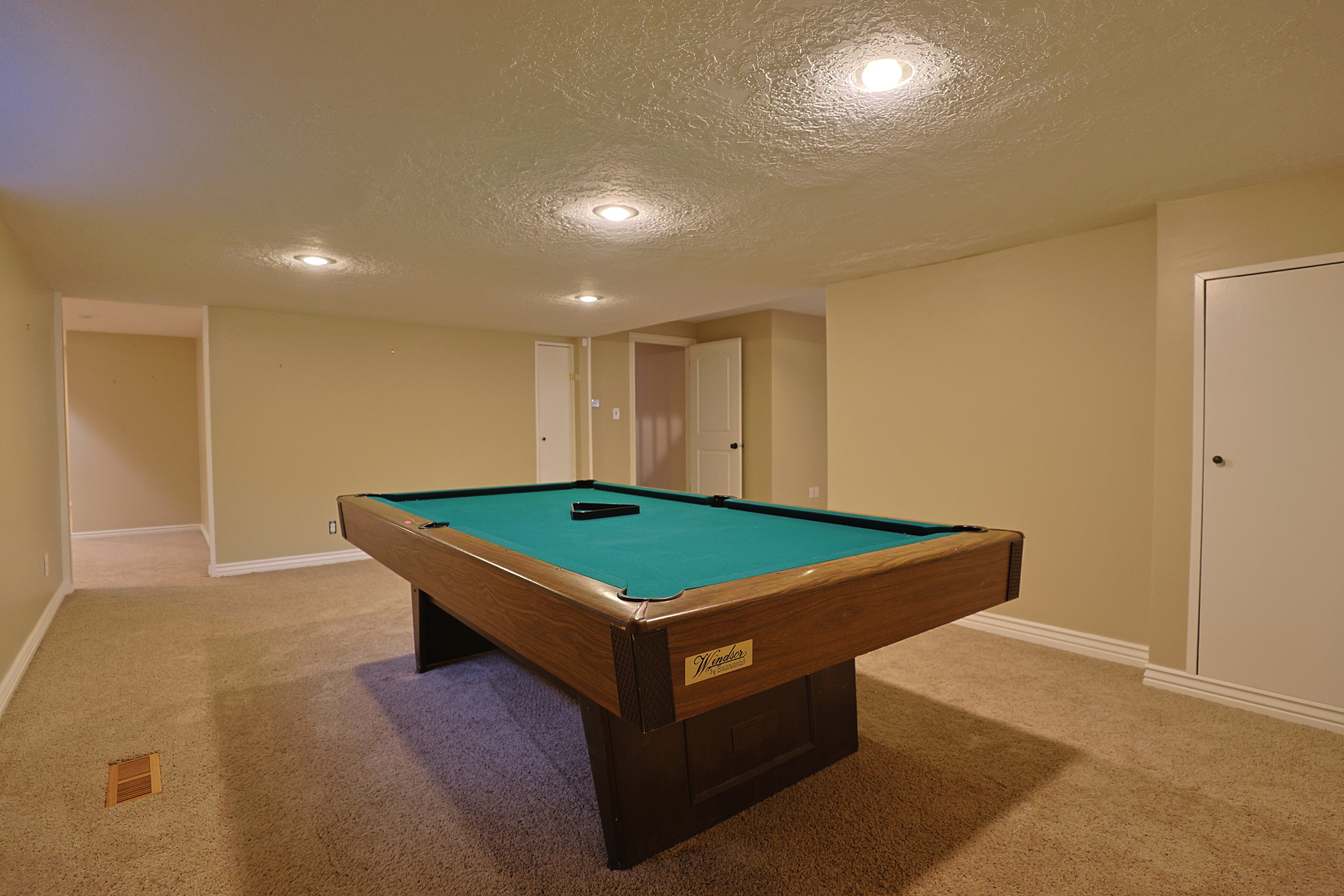 Recreation room with billiards table, a textured ceiling, light colored carpet, and recessed lighting