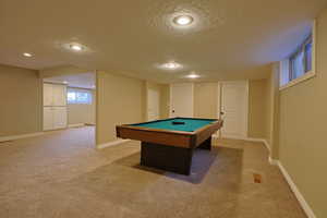 Rec room featuring a textured ceiling, pool table, light carpet, and recessed lighting