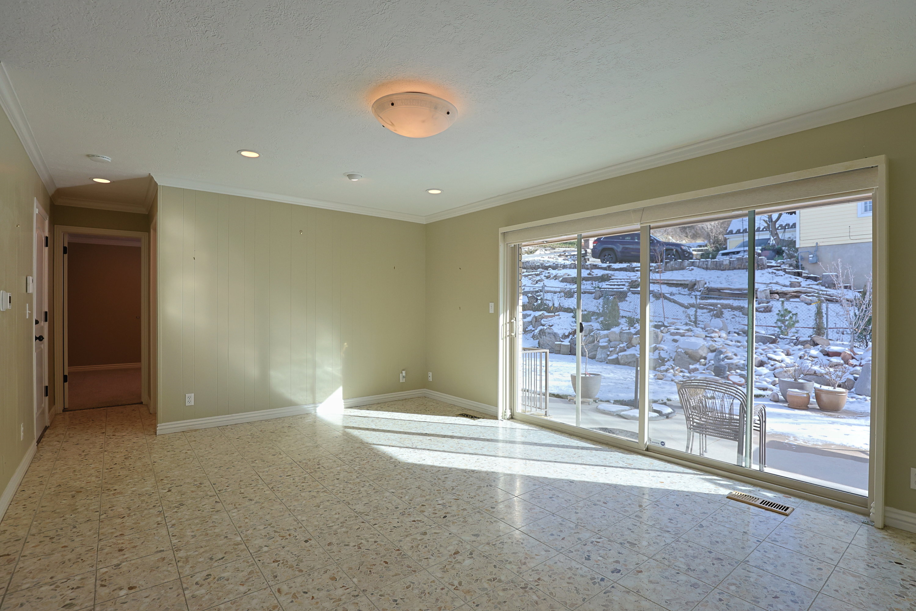 Spare room featuring light floors, crown molding, and a textured ceiling