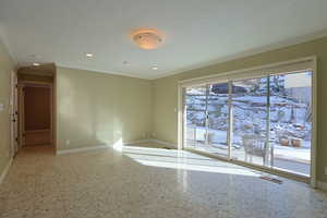 Spare room featuring light floors, crown molding, and a textured ceiling