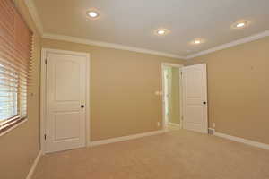 Unfurnished bedroom featuring carpet flooring, crown molding, a textured ceiling, and recessed lighting